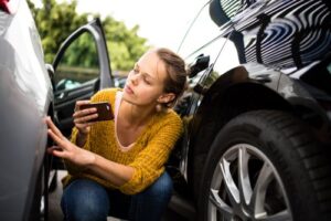 Woman Taking Pictures of Car Damage