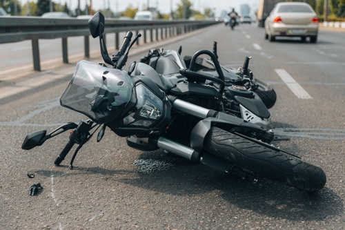 Motorcycle accident scene with a damaged motorcycle lying on its side on the road, highlighting the aftermath of a crash relevant to Wilmington motorcycle injury claims.