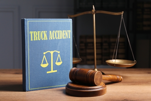 Book titled "Truck Accident" next to a wooden gavel and a balanced scale, symbolizing legal representation for truck accident victims in Wilmington.