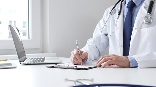 Doctor Filling Out Medical Records