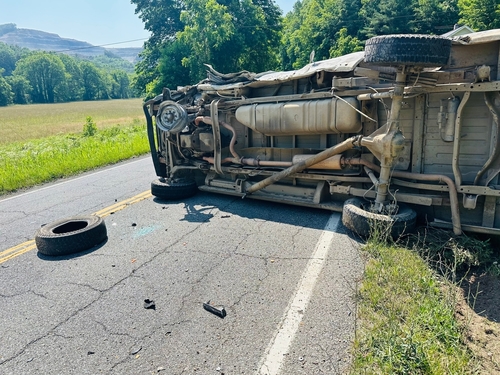 Overturned truck on rural road with scattered debris, illustrating the aftermath of a truck accident in Wilmington, emphasizing the need for legal representation and liability investigation.