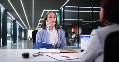 Woman wearing a neck brace meeting with a Wilmington pedestrian accident lawyer for legal guidance after an injury.