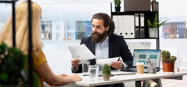 A personal injury attorney reviewing auto accident liability case documents with the client to determine fault and compensation options.