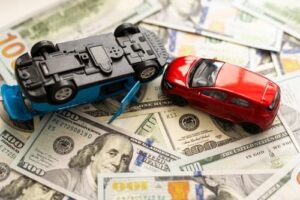 Toy cars on pile of money represent car accident compensation in North Carolina.