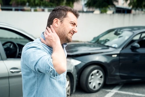 A man with neck pain who needs a rideshare accident attorney