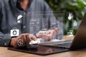 A person types on a laptop as a holographic insurance interface floats above it displaying vehicle coverage details- medical icons- time indicators- and cost symbols illustrating the digital process of researching and filing common car accident claims with an insurer in North Carolina.