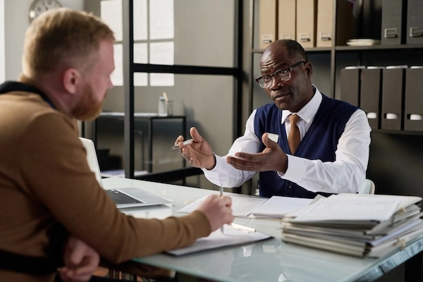 A truck accident lawyer is speaking with a client at North Carolina Car Accident Lawyers in Charlotte.